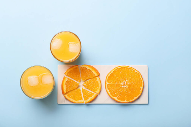 Sklenice čerstvé pomerančové šťávy a ovoce na barevném pozadí - Fotografie, Obrázek