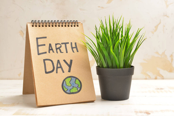 Notebook szöveges Earth Day és növény a fény háttér - Fotó, kép