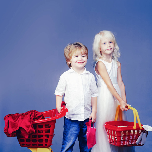 Buy products. Play shop game. Cute buyer customer client hold shopping cart. Girl and boy children shopping. Couple kids hold plastic shopping basket toy. Kids store. Mall shopping. Buy with discount - Foto, Bild