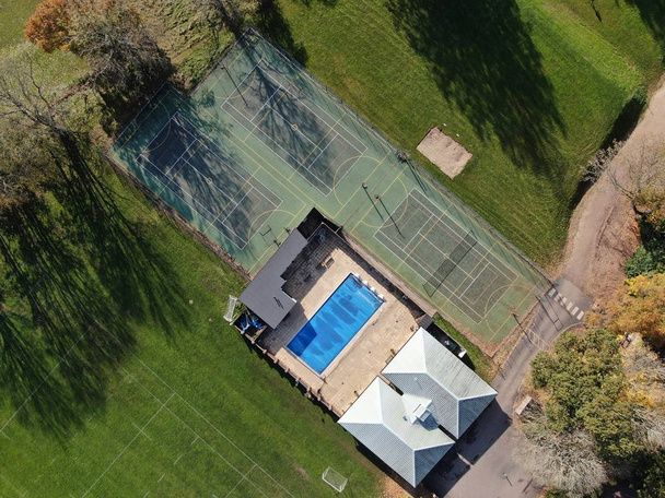 An aerial view looking down on tennis courts and a swimming pool  - Photo, Image