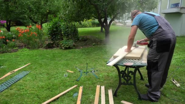 Pracovník s ochrannou maskou a leštícími dřevěnými deskami s bruskou - Záběry, video