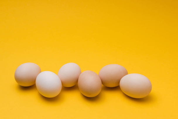 natürliche Eier auf gelbem Hintergrund. Entwurf für Lebensmittelmarkt-Aktion - Foto, Bild