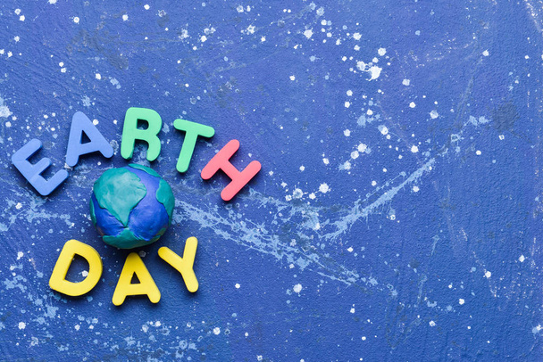 Planet and text EARTH DAY on color background - Photo, Image