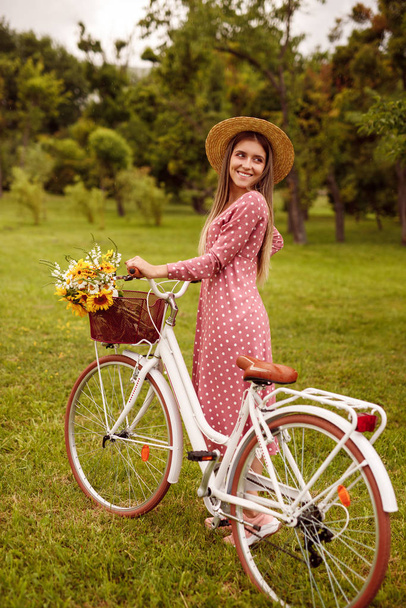 Веселая женщина с ретро-велосипедом в парке
 - Фото, изображение