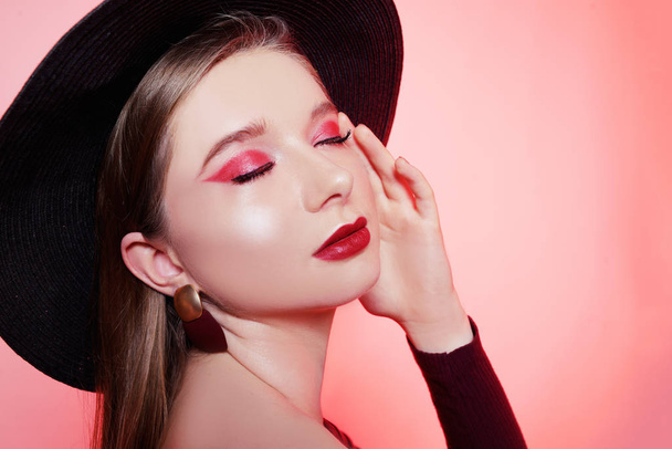 Hermosa rubia en un gran sombrero con maquillaje de color burdeos, labios rojos, un
 - Foto, imagen