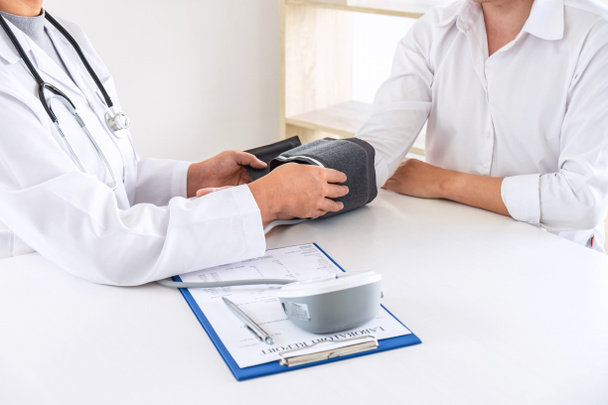 Lääkäri käyttää verenpainemittari ja stetoskooppi tarkkailun
 - Valokuva, kuva