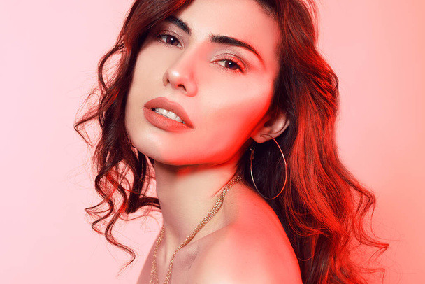 Gorgeous brunette with wrap hair portrait. Girl on a pink-red ba - Photo, Image