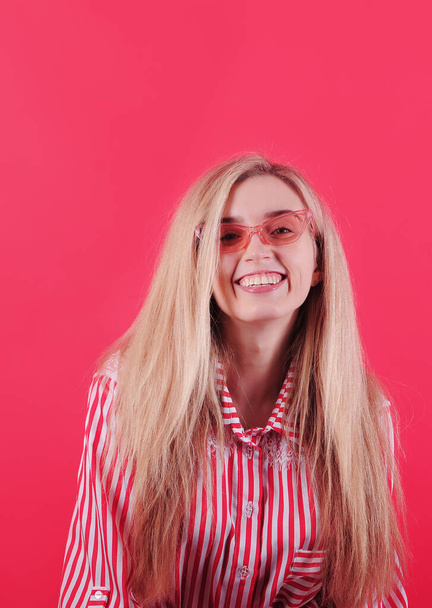 Beautiful smiling woman posing on red background.  - Valokuva, kuva