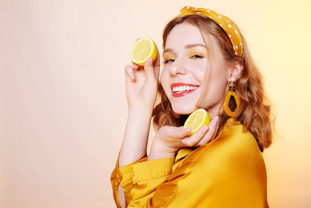 Krásná dívka, žlutý make-up, světlé barvy. Dívka drží citrony - Fotografie, Obrázek