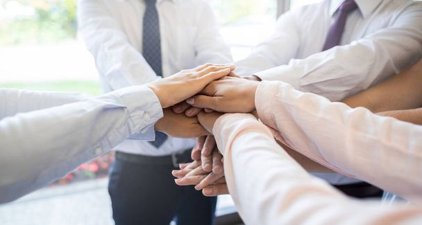 Nahaufnahme von jungen Geschäftsleuten, die ihre Hände zusammenlegen. Stapel von Händen. Einheit und Teamwork-Konzept. - Foto, Bild