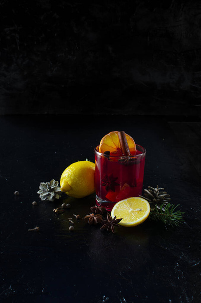 festive cocktail with lemons fir branches and spices on a black background - Zdjęcie, obraz