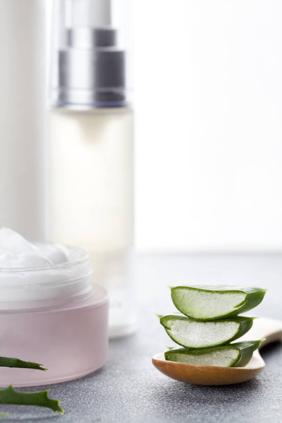 Aloe vera sliced leaves and natural cream, lotion and tonic on white background - Photo, Image