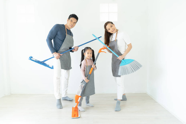 Πορτρέτο του νεαρού ευτυχισμένη ασιατική οικογένεια καθαρισμού στο σπίτι και παίζοντας w - Φωτογραφία, εικόνα