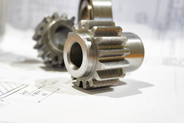 The gear after manufacturing on the gear cutter lies on the technical drawing. - Photo, Image