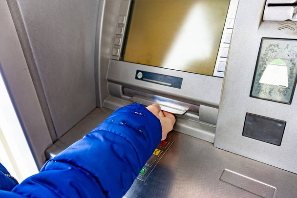 Een vrouw op een Atm neemt cash hryvnia 's in Oekraïne, 100 en 500 hryvnia biljetten. - Foto, afbeelding