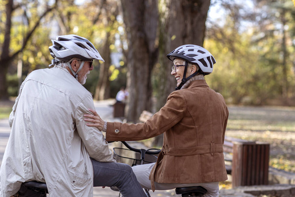 Vecchia donna e uomo in parco con biciclette
 - Foto, immagini