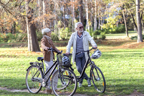 Öreg nő és férfi a parkban kerékpárral - Fotó, kép