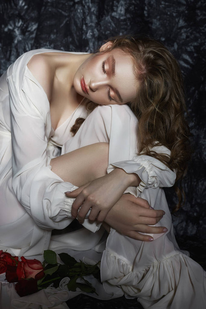 Beautiful spring girl is sitting on the floor with rose flowers  - Foto, immagini