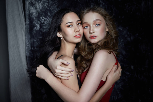 Beauty spring portrait of two girls on a dark background. Women  - Zdjęcie, obraz