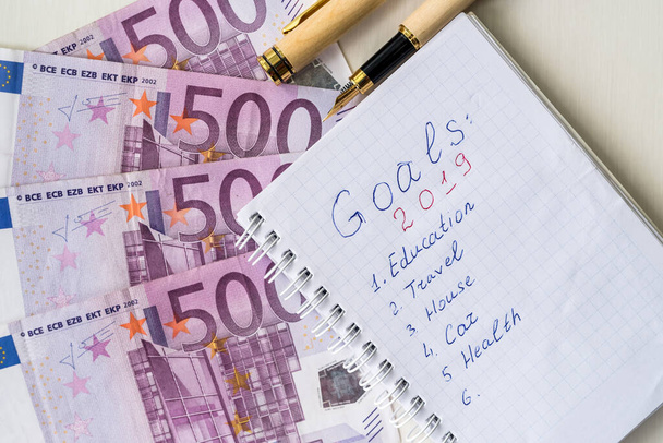 Notizblock mit Zielen für 2019 und Euro-Banknoten auf dem Tisch - Foto, Bild
