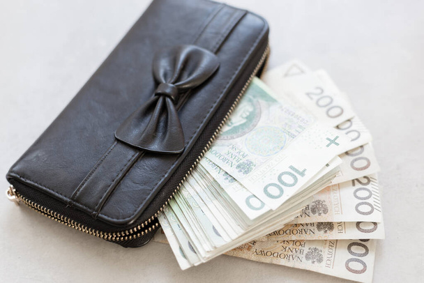 Menina rica ou mulher da Polônia, bolsa preta bonito com um arco, cheio de dinheiro polonês
.  - Foto, Imagem