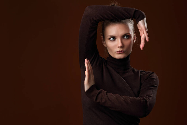 Beautiful girl in a maroon turtleneck on a brown background - Photo, image