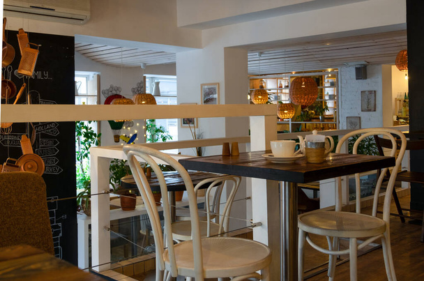 El interior de la cafetería es vintage con lámparas de mimbre, muebles de madera y elementos de diseño
. - Foto, Imagen