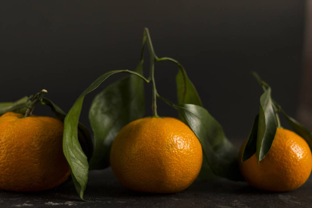 Orange tangerines on a black background. There is a place for text. - Фото, изображение