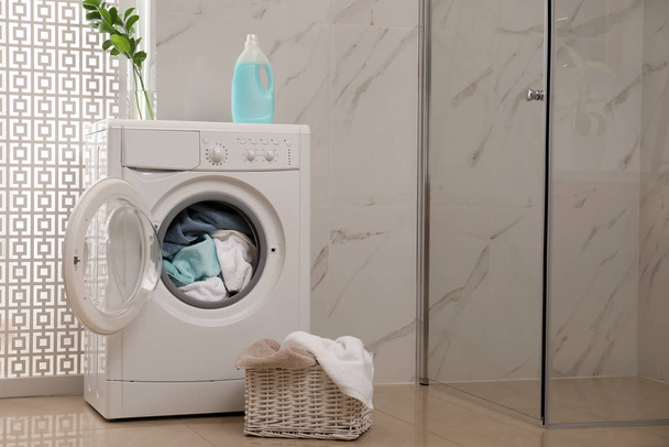 Modern washing machine with towels in bathroom - Foto, Bild