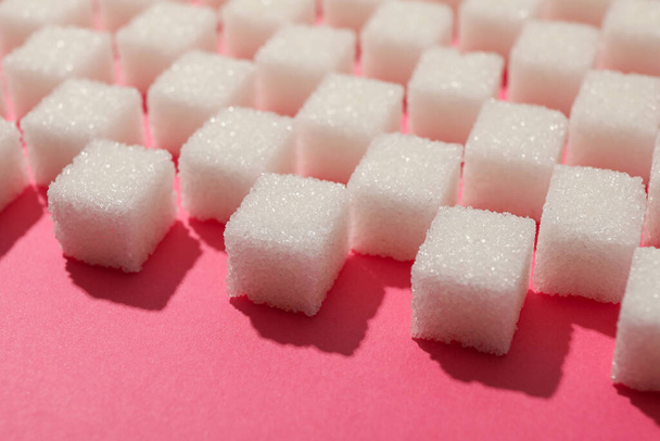 Muitos cubos de açúcar no fundo rosa, close-up
 - Foto, Imagem