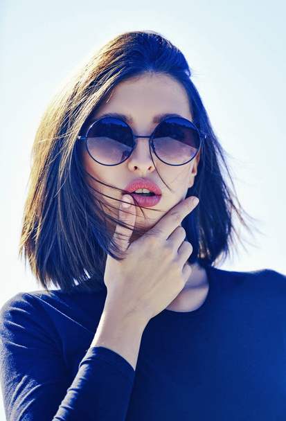 Female fashion model posing with sunglasses. Close-up portrait of a beautiful charming young attractive lady. Portrait of serious woman in the light isolated. Beauty and fashion. - Foto, immagini