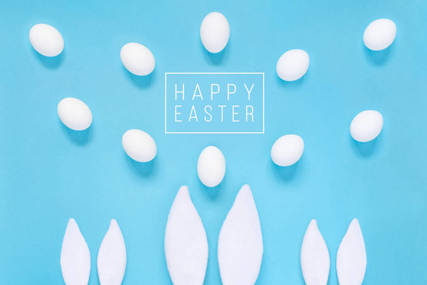 Flat lay composition of creative Easter bunny ears on blue background, space for text - Foto, Imagem
