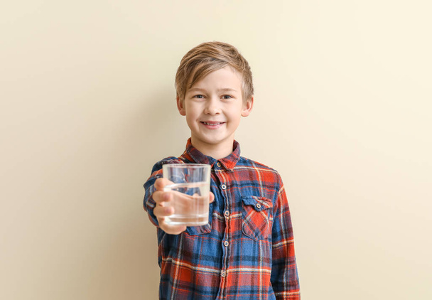 Cute little boy with glass of water on color background - Foto, Imagem