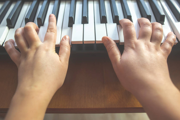 Gros plan de mains de jeune femme jouant sur le piano, instrument
 - Photo, image