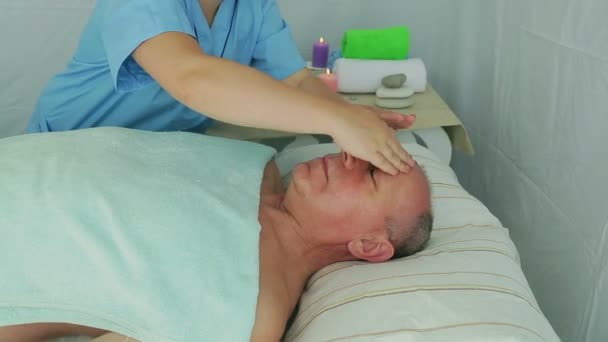 Kobieta kosmetyczka daje klientowi mężczyznę tonik masaż twarzy w salonie Spa - Materiał filmowy, wideo