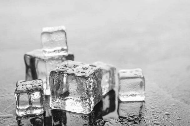 Crystal clear ice cubes with water drops on light grey table, closeup. Space for text - Foto, Imagem