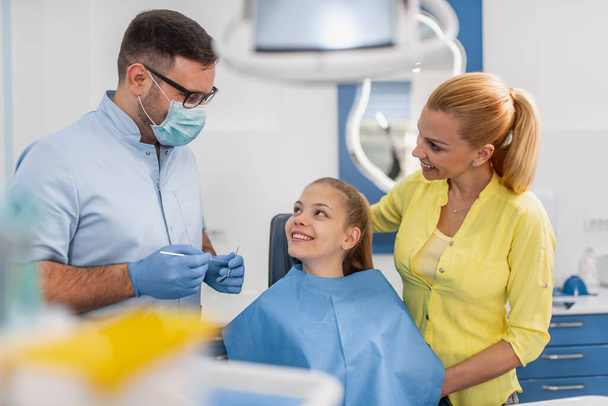 Tandarts behandeling van een patiënt tanden in het kantoor van de tandarts  - Foto, afbeelding