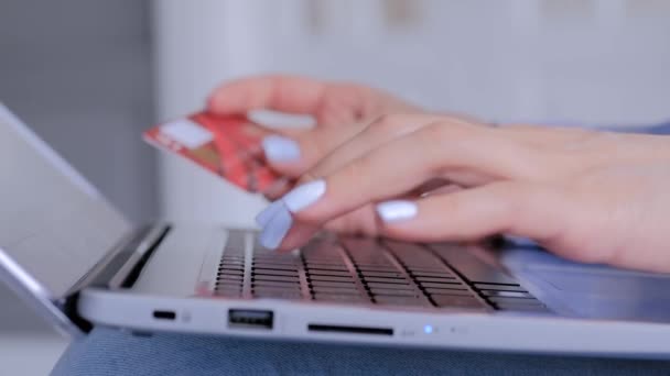 Las manos de la mujer utilizando el teclado de ordenador portátil y tarjeta de crédito para compras en línea - Metraje, vídeo