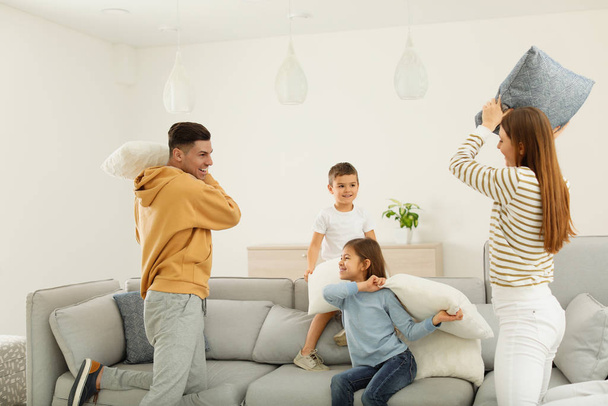 Happy family having pillow fight in living room - Foto, imagen