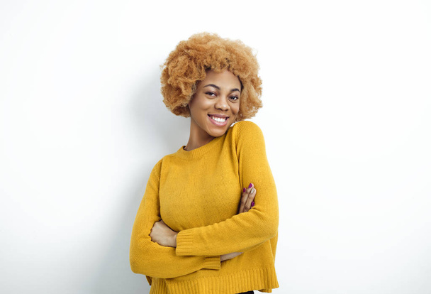 白地を指差して笑うアフリカ系アメリカ人の若い女性の肖像画。美しいです幸せな黒女性とともに巻き赤い髪. - 写真・画像