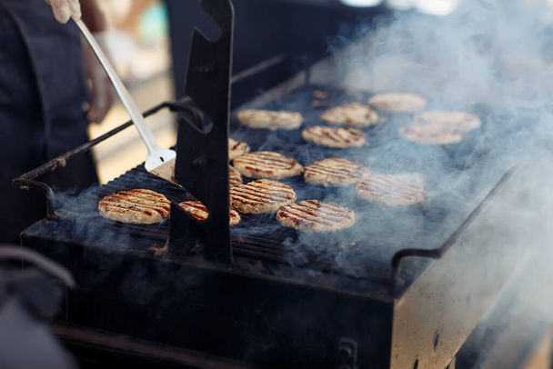 The grilling process of preparing meat cutlets for burgers - 写真・画像