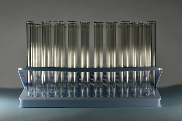 The tray with test tubes in the shade is partially illuminated by a horizontal beam. - Foto, Imagem