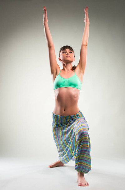 Beautiful young woman doing yoga exercise. - Fotó, kép
