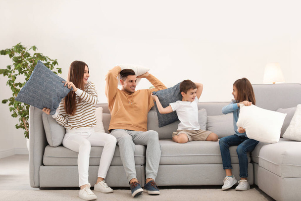 Happy family having pillow fight in living room - Фото, зображення
