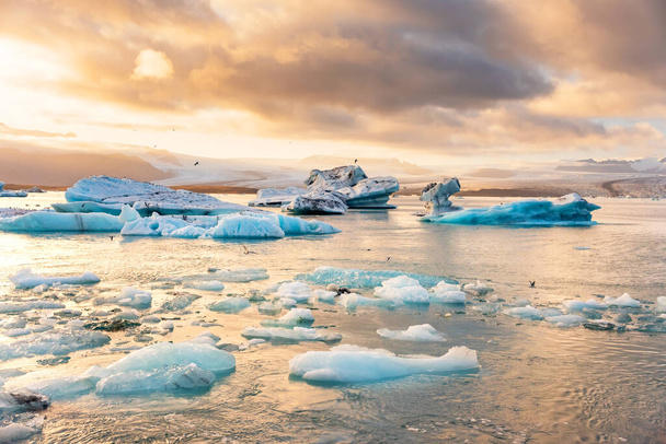 Icebergs floating in Jokulsarlon glacier lagoon lake at sunset - 写真・画像