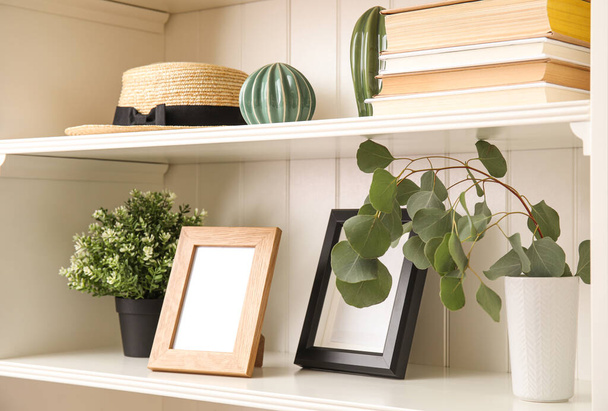 White shelving unit with plants and different decorative stuff - 写真・画像