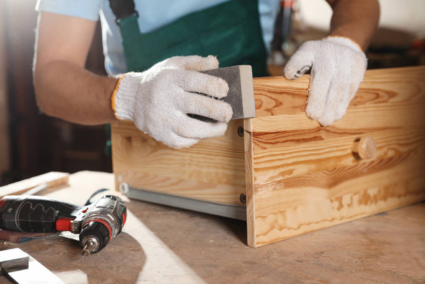 Επαγγελματική ξυλουργός στίλβωση ξύλινο συρτάρι στο εργαστήριο, closeup - Φωτογραφία, εικόνα