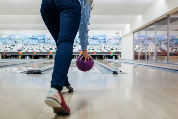 Jogo de bowling. Mulher se divertindo jogando bowling no clube jogando bola. Close up de pernas e sapatos
 - Foto, Imagem