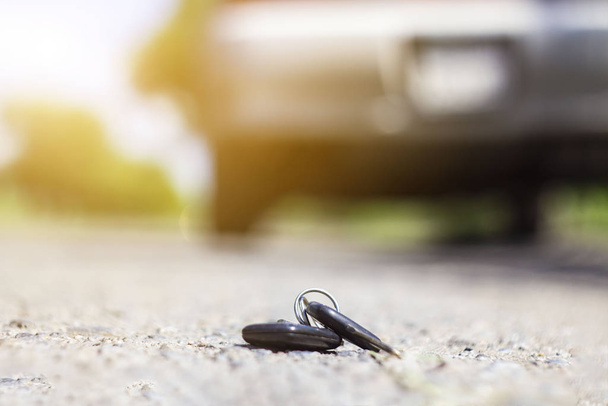 道に横たわる迷子の車の鍵を背景に - 写真・画像