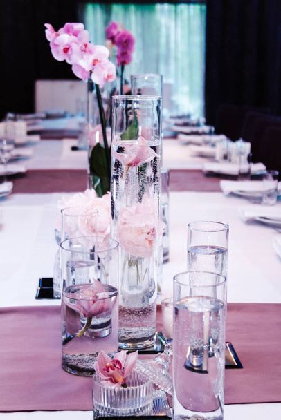 Obsługiwanie stołów w restauracji z piwoniami i storczykami - Zdjęcie, obraz